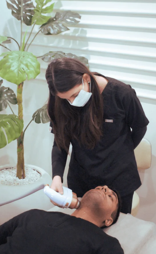 A practitioner performing a HIFU treatment in Pakistan on a male patient's jawline.